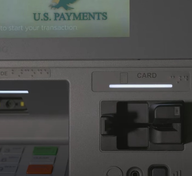 Close-up of an ATM card slot and screen displaying U.S. PAYMENTS with an eagle logo.